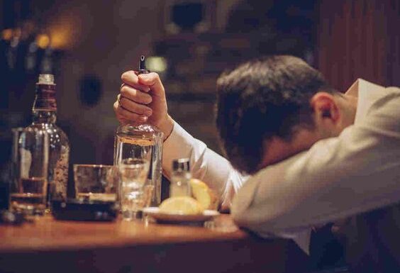 Man showing signs of alcohol addiction at a bar, a common symptom of Alcohol Use Disorder needing treatment in Nagpur